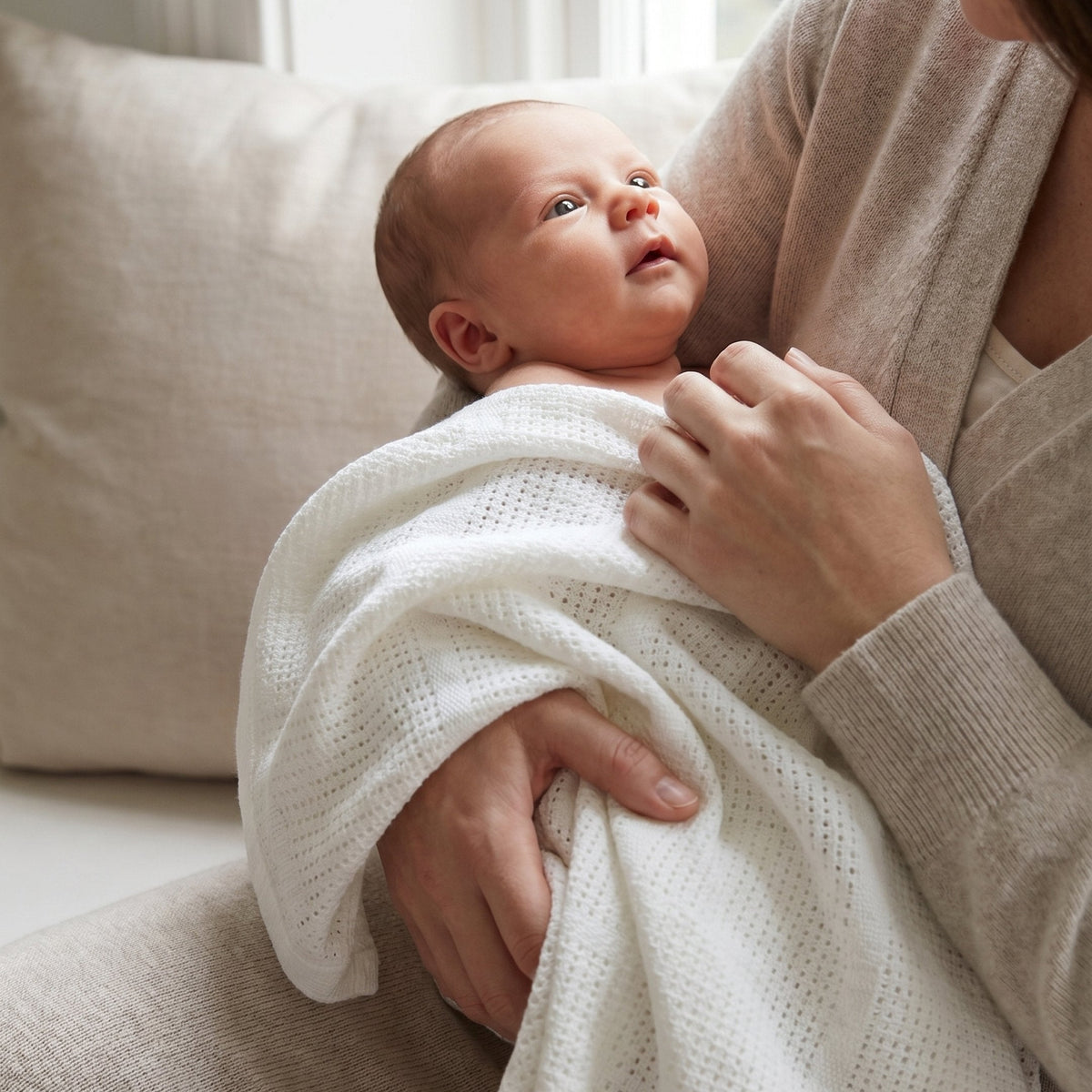 Newborn held in a Cloud organic cotton cellular blanket