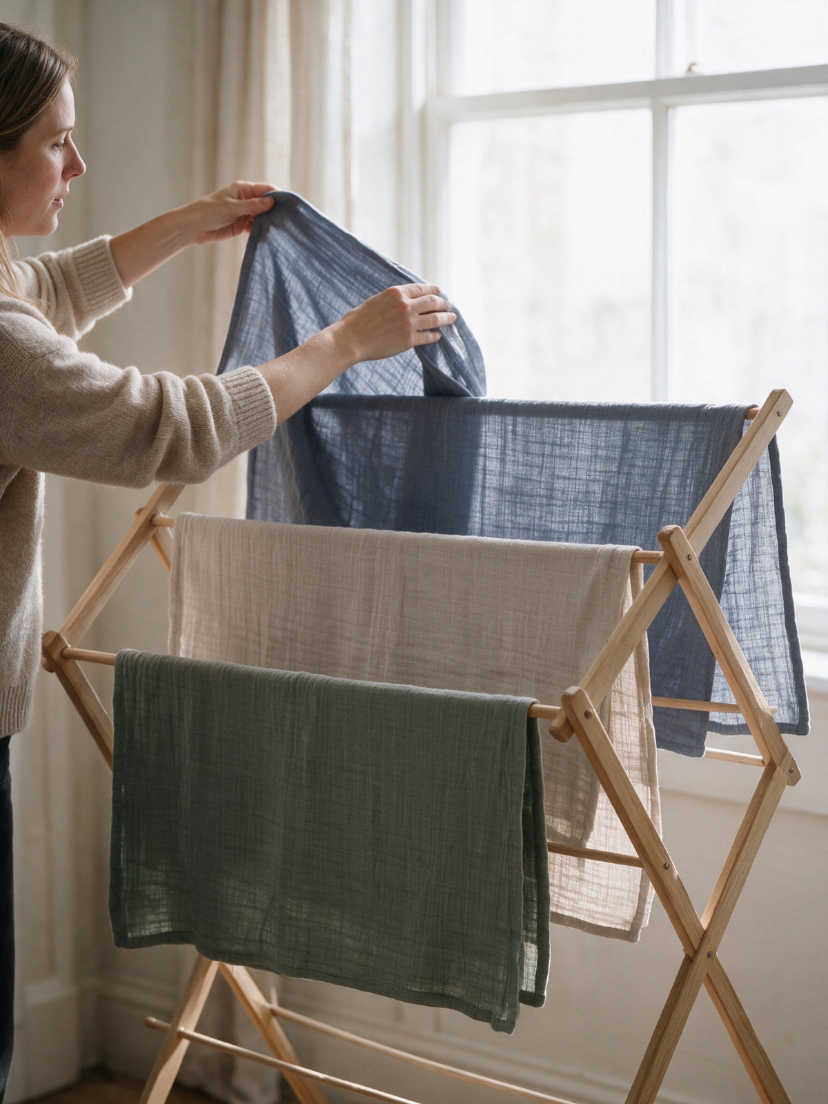 Muslin swaddles drying on a wooden rack